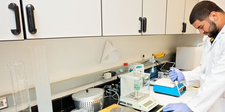 Undergraduate researcher Alex Turner runs samples in the lab