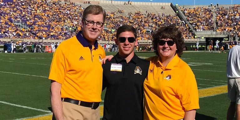 East Carolina University freshman Michael Hinson (center) is honored alongside Chancellor Cecil Staton and his wife, Catherine, at the Pirates’ football game against Old Dominion University. Hinson and a group of friends collected nearly 40,000 pounds of goods for those affected by Hurricane Florence. (Contributed Photos)