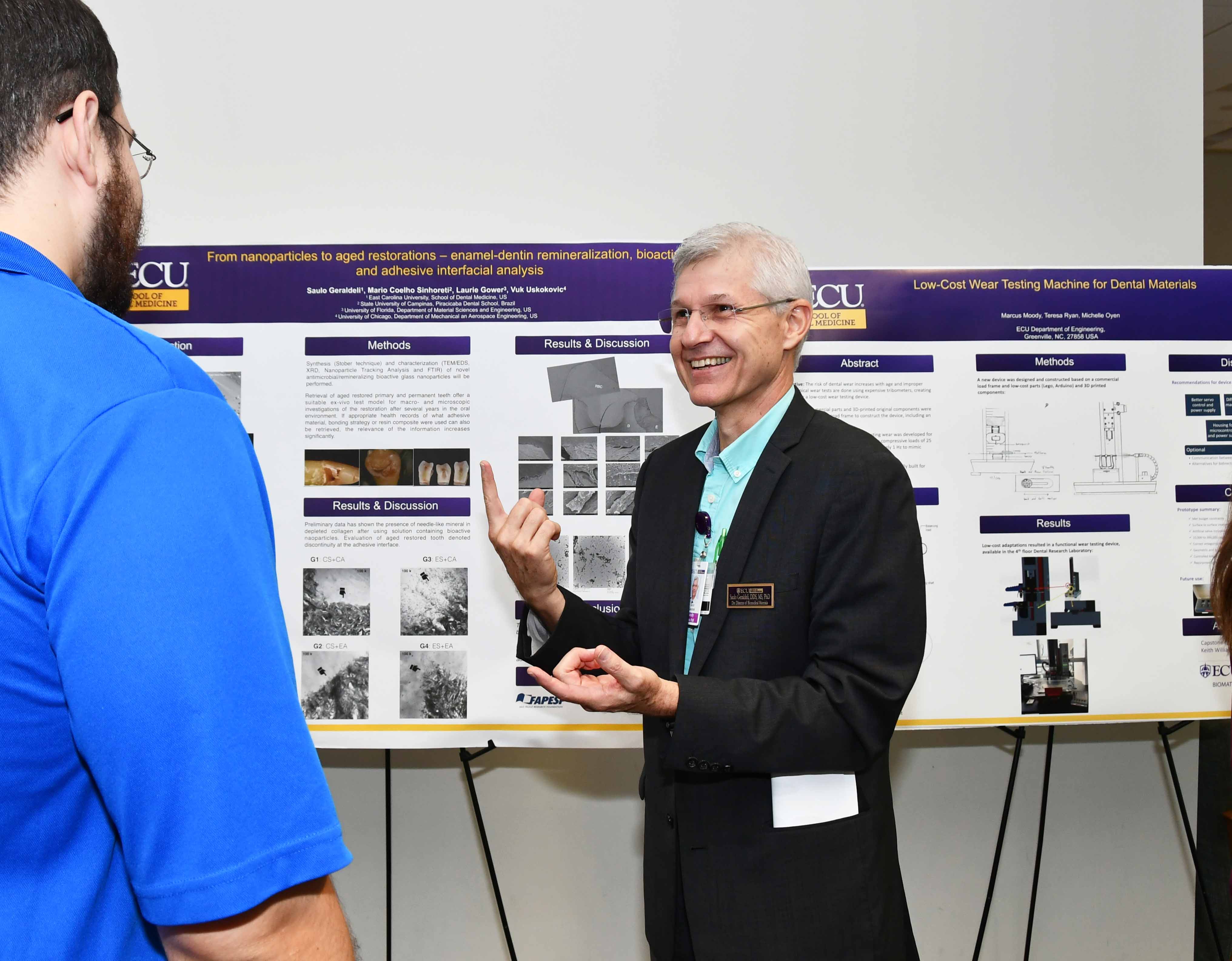 Presenter shares research poster at Dental School event