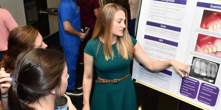 Third-year dental student Skyler Lagcher discusses her poster presentation “Ectopic Sebaceous Gland: Atypical Presentation” with students at the ECU School of Dental Medicine’s fifth annual Celebration of Research and Scholarship on Aug. 21.
