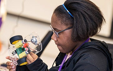 Female student works on robot